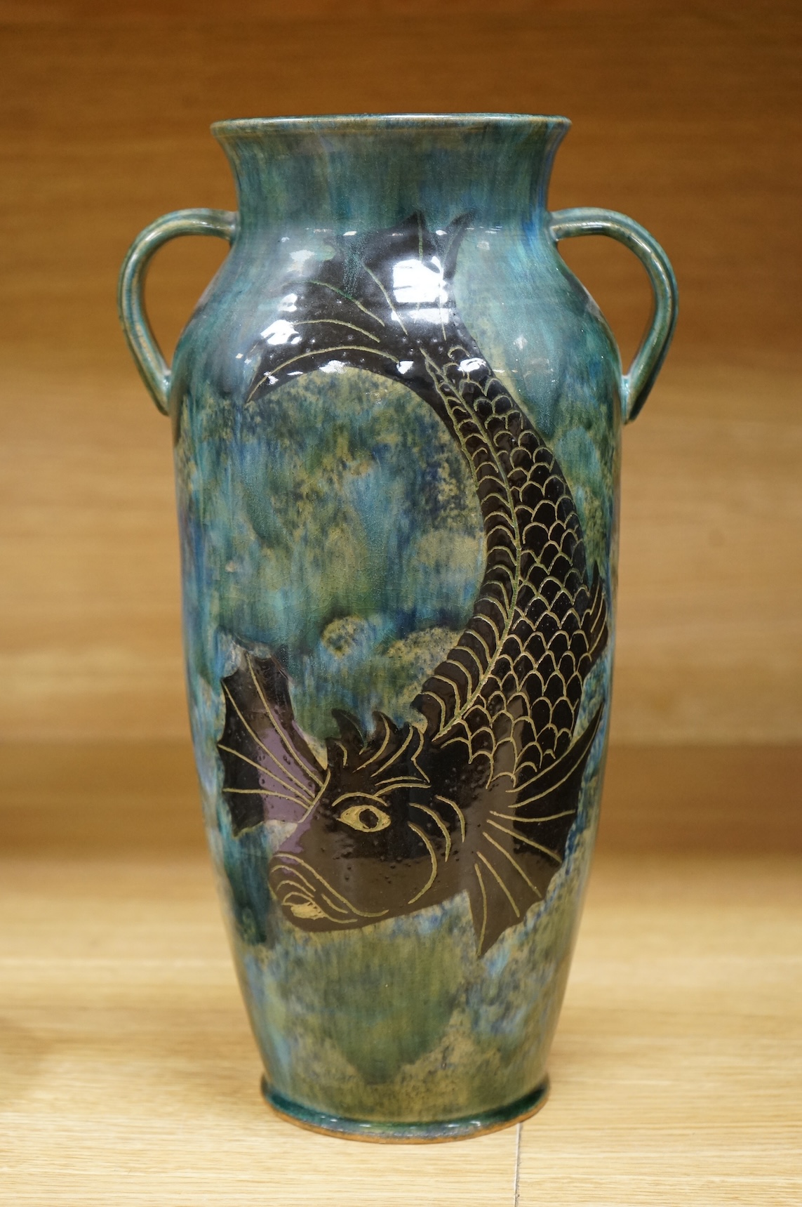 Jane Bridger, a fish designed, green glazed studio pottery two handled vase. 34cm high.